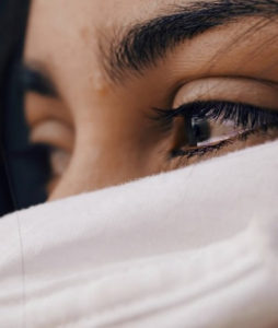 Woman with only eyes visible beneath white scarf